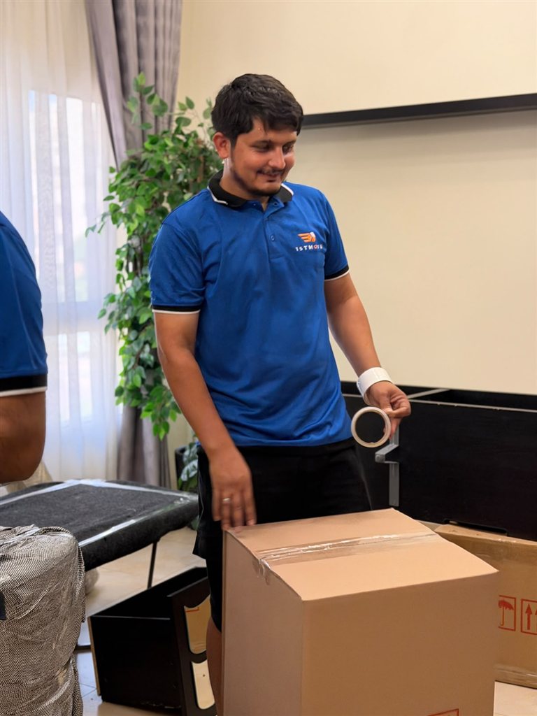 Real 1stMove crew member loading wrapped furniture into a branded moving truck