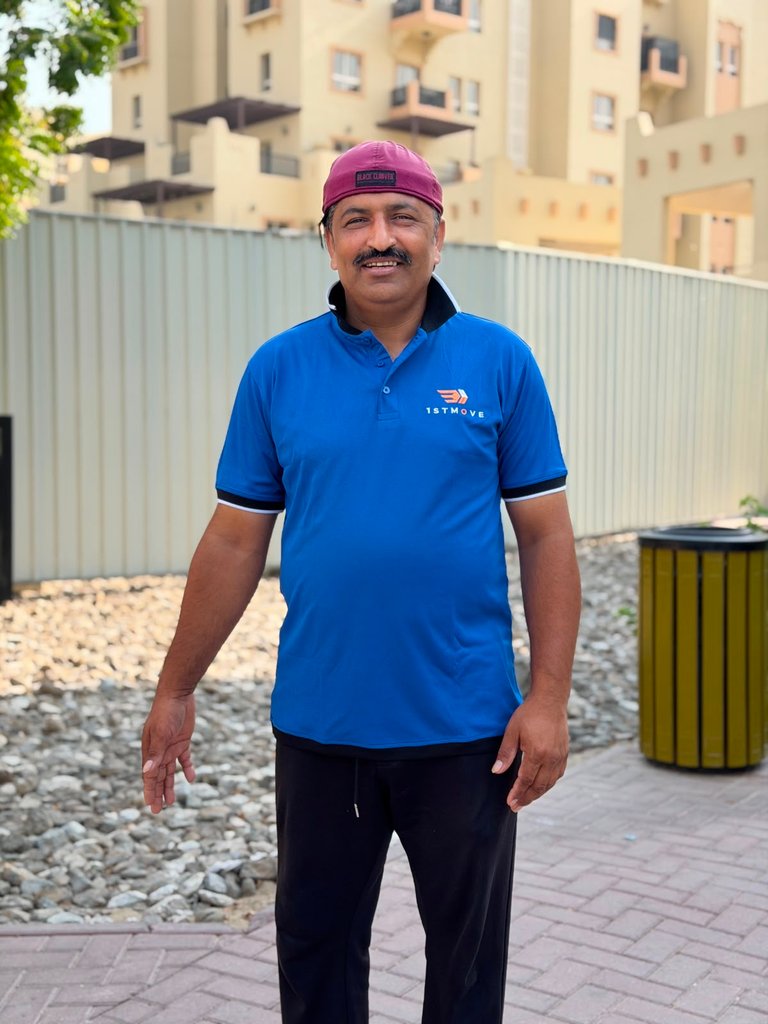 Real 1stMove crew member in company uniform outside a gated villa-style community